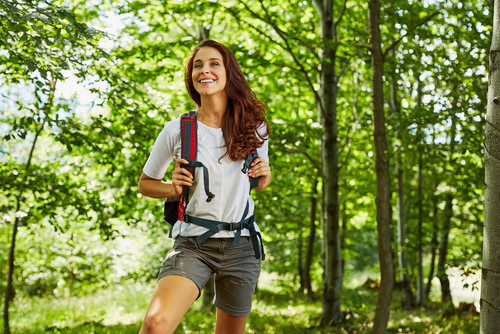 happy_woman_hiking Happy woman hiking outside in the woods smiling